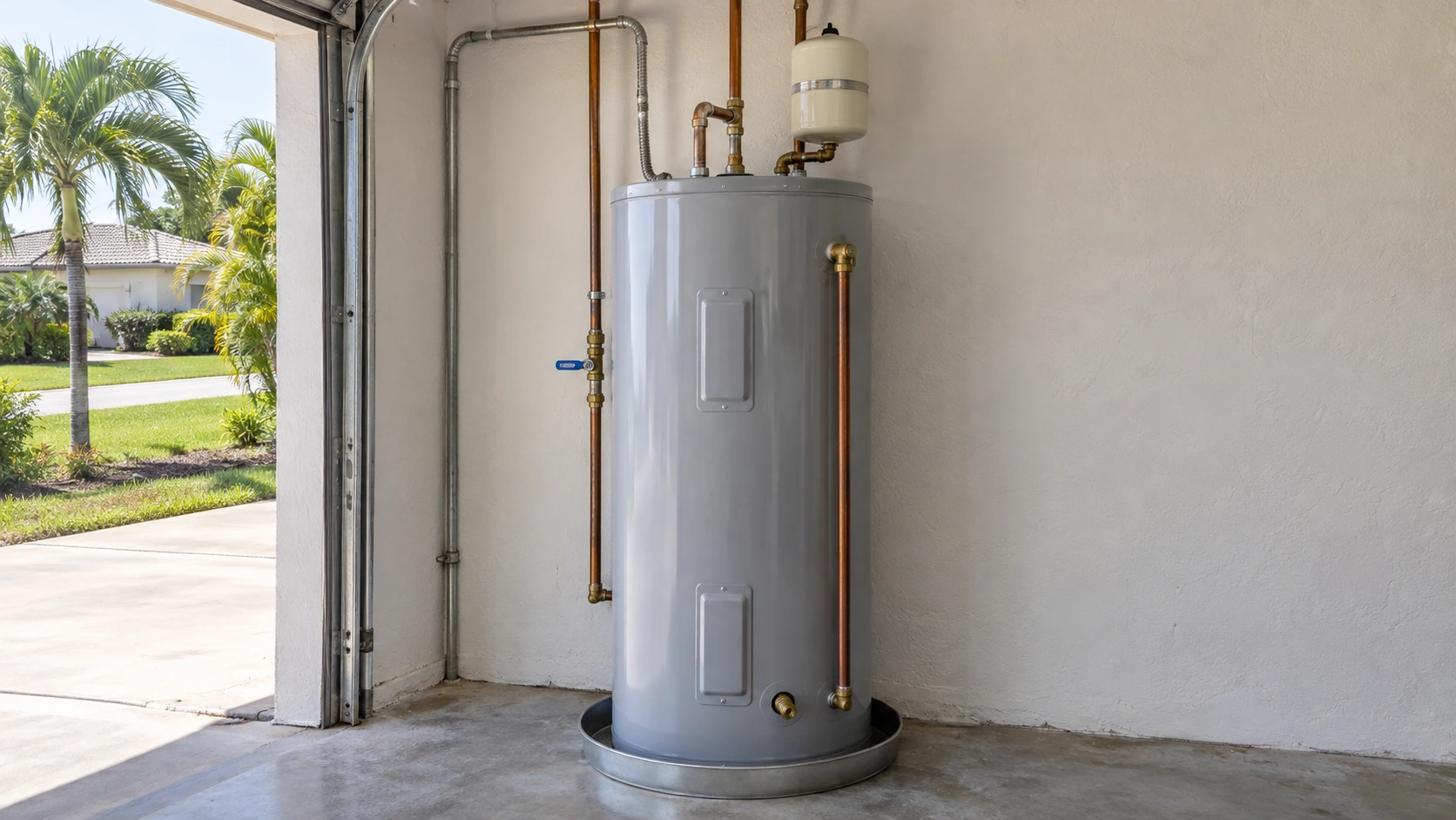 A residential water heater, supply pipes and shutoff in a bright South Florida garage